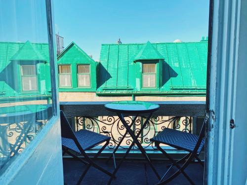 魁北克市皮埃尔别墅酒店的阳台配有桌子和两把椅子,公寓大楼