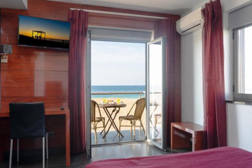 纳扎雷Hotel Oceano的一间卧室设有一张床和一张书桌,享有海景
