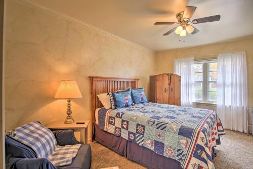 塔尔萨Ranch-Style Cottage - 2 Miles to Philbrook Museum!的一间卧室配有一张床、风扇和椅子