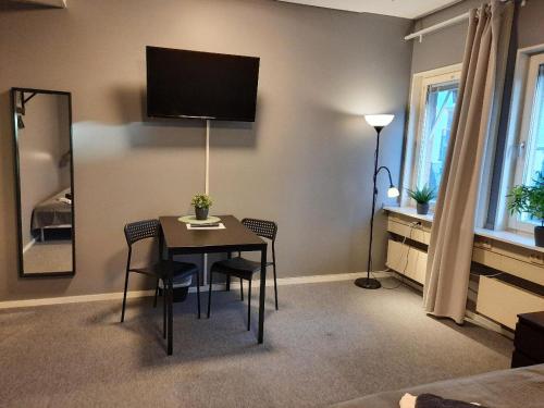 乌普萨拉Vandrarhem Uppsala - Portalgatan的配有桌椅和墙上电视的房间