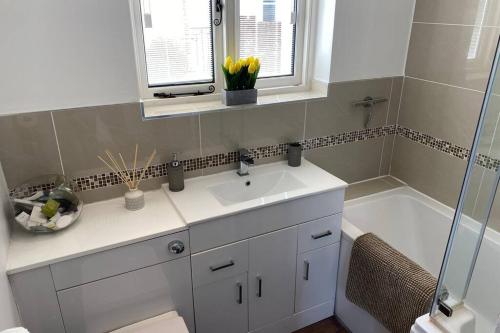 贝辛斯托克Overton Annexe的浴室配有水槽、淋浴和浴缸。