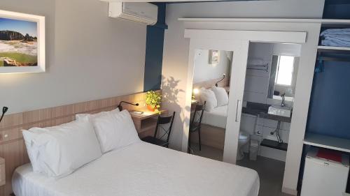 托雷斯郁金香酒店的酒店客房带一张床铺、一张书桌和一间卧室