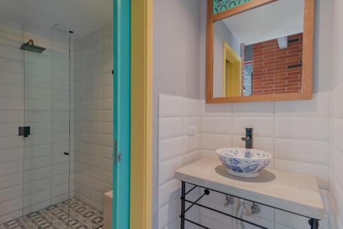 麦德林Masaya Medellin的一间带水槽、镜子和淋浴的浴室