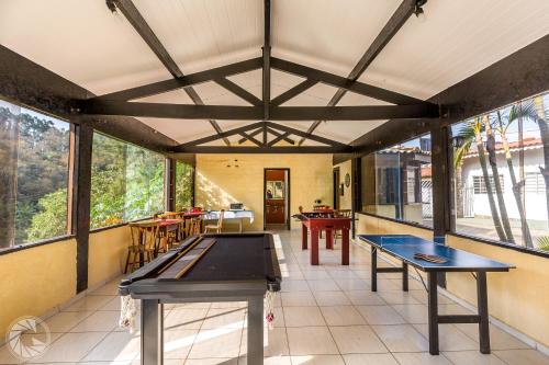 阿蒂巴亚Pousada Atibaia的一间设有两张乒乓球桌和窗户的房间