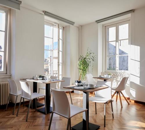 特伦托Lainez Rooms & Suites的用餐室设有桌椅和窗户。
