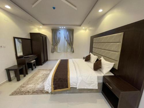 艾卜哈ابيات ميرا的一间大卧室,配有一张大床和一张书桌