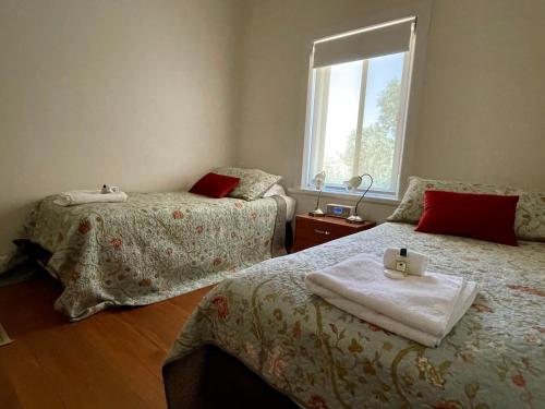 Angaston兰伯特庄园度假酒店的一间卧室设有两张床和窗户。