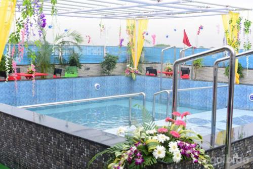 丹巴德Hotel Madhuvan by TravelkartOnline的一座大游泳池,在建筑里种满鲜花