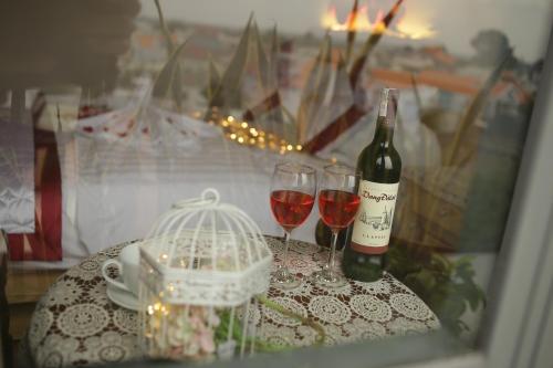 边和Hotel Như ý Biên Hòa的一张桌子,上面放着两杯酒和一瓶葡萄酒