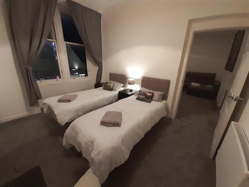 邓弗姆林Carvetii - Edward House A - 2 Dbl bed 1st floor flat的一间卧室配有两张床和一张沙发。