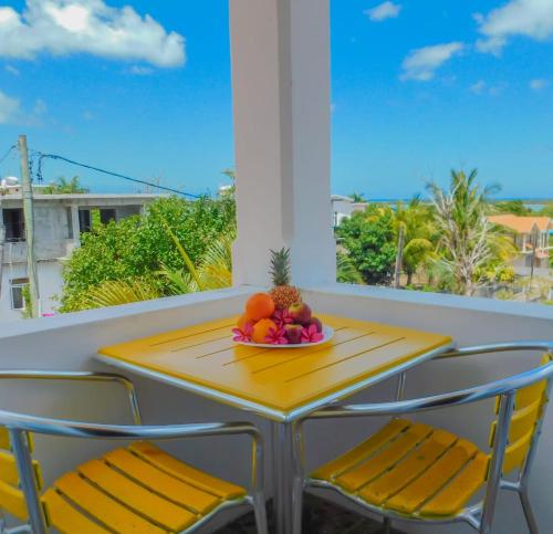 拉戈莱特Tulsi Apartment & Studio的阳台上配有桌椅和一碗水果
