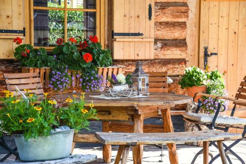 维尔芬翁阿尔卑斯弗洛拉小屋的庭院里摆放着木桌和鲜花椅