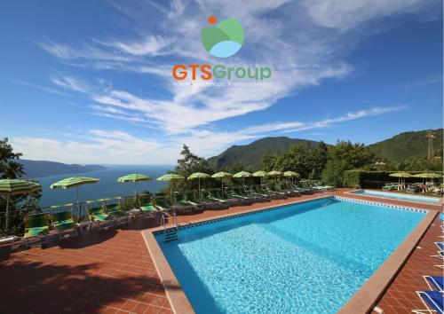 提尼亚类Hotel Residence Panorama La Forca, GTSGroup的度假村的游泳池,配有椅子和遮阳伞
