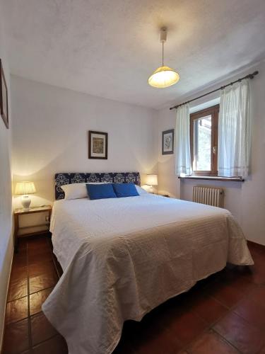 科涅L'Atelier du Temps - Il Prato di Maria的一间卧室设有一张大床和一个窗户。