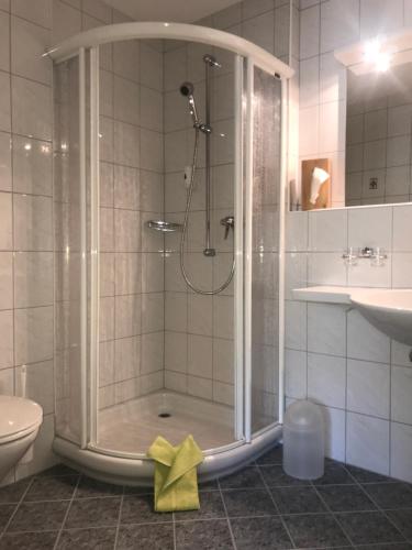 萨姆瑙恩奥罗拉加尔尼酒店的浴室里设有玻璃门淋浴