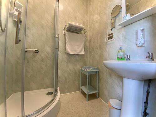 莱瑟姆-圣安妮Cumbria Guest House的带淋浴、盥洗盆和卫生间的浴室
