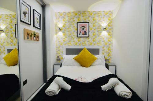雷丁Executive Central Self Contained Flat by CozyNest的卧室配有一张带黄色枕头的大型白色床。