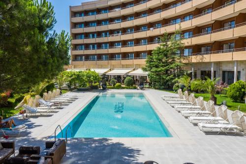 帕莫瑞帕莫瑞大酒店的一个带躺椅的游泳池和一间酒店