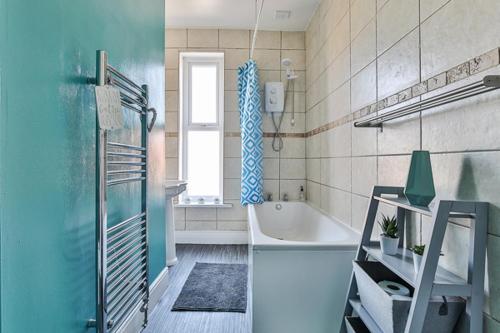 谢菲尔德Heart of the City-Flexi Cancellations-Central Hub的蓝色的浴室设有浴缸和淋浴。
