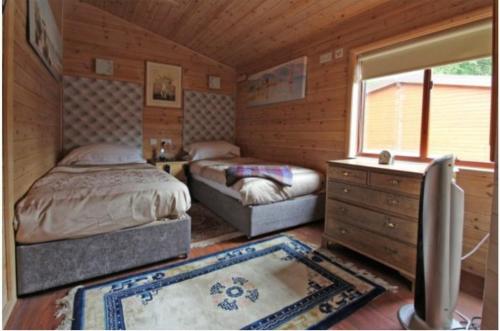 EardingtonAstbury Falls Luxury Retreats的一间卧室设有两张床、一个梳妆台和窗户。