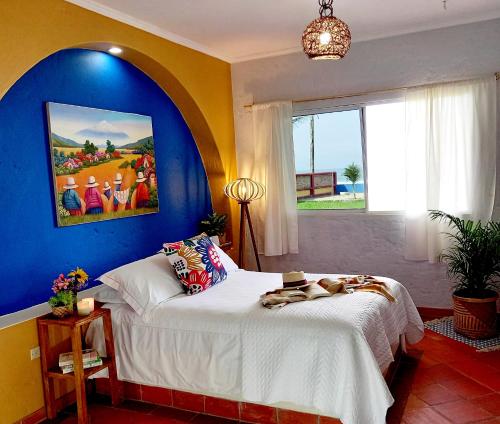 卡约港Casa Amarilla的一间卧室设有一张蓝色墙壁的大床