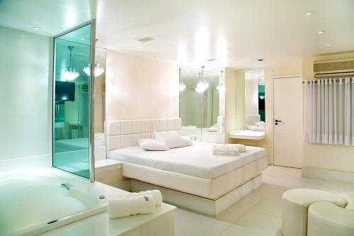里约热内卢BAMBINA HOTEL -Adultos Somente的白色的浴室设有床和浴缸。