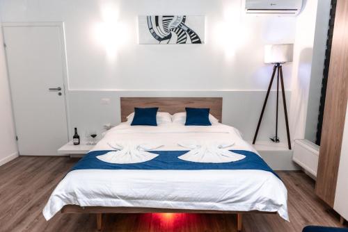 克拉约瓦Puzzle Apartaments&Studios的卧室配有带蓝色枕头的大型白色床