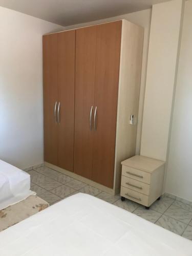 伊瓜苏Apartamento foz centro 03的一间卧室配有一张床和一个木制橱柜