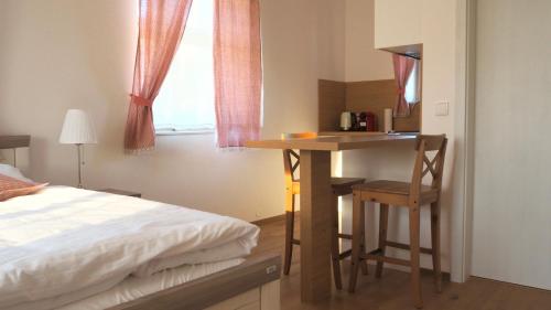 斯拉沃尼采Apartmány Na Potoku的一间卧室配有一张床和一张桌子及椅子