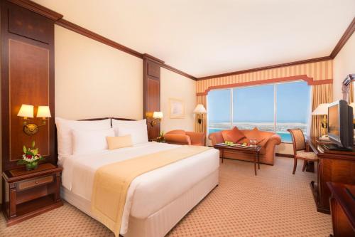阿布扎比阿布扎比海滨大道酒店的一间带大床的卧室和一间客厅