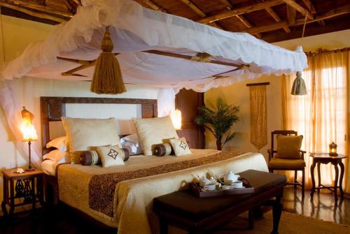 布韦朱桑给巴尔帕玛斯度假村的一间卧室配有一张带天蓬的大床
