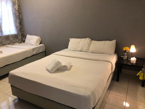 彭亨Bentong Makmur Guesthouse的酒店客房,配有两张带毛巾的床