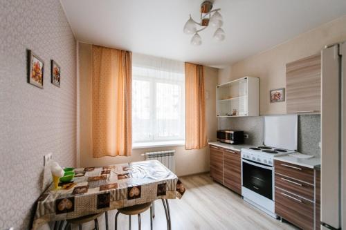 赤塔Apartment on Bogomyagkova的一间带桌子的厨房和一间带炉灶的厨房