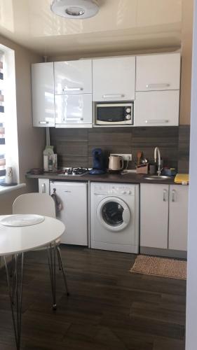 哈尔科夫Сдам посуточно однакомнатную квартиру的厨房配有白色橱柜和洗衣机。