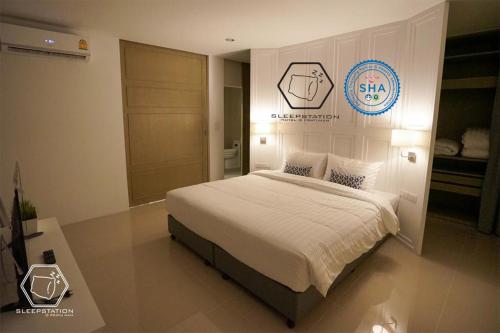 曼谷水门市场雅眠居酒店的卧室配有一张床,墙上有标志