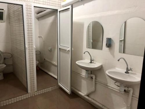纳祖尔Hotel El Maghreb Al Kabir的浴室设有2个盥洗盆和带镜子的淋浴。