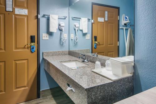 卡罗尔顿Rodeway Inn Carrollton I-35E的一间带水槽和镜子的浴室