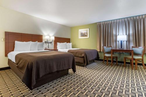 切罗基切诺基经济酒店的酒店客房带两张床和一张桌子以及椅子。
