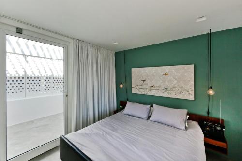 西尔韦斯卡萨艾克斯纳度假屋的一间卧室设有绿色的墙壁、一张床和一个窗户