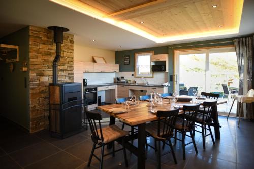 SoultzerenLe Domaine d'Emma : Le Golden的厨房以及带木桌和椅子的用餐室。