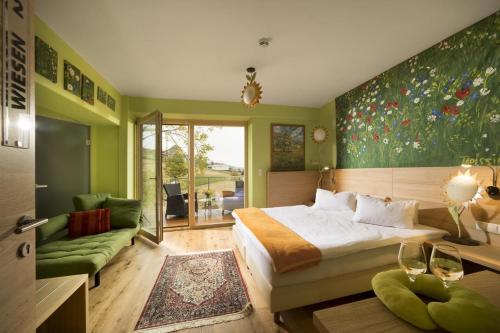 HatzendorfMalerwinkl Restaurant + Kunsthotel的一间卧室设有一张大床和绿色的墙壁