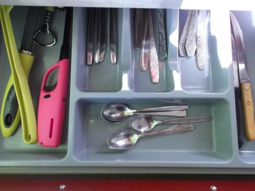 塔林Hansa Apartment的抽屉里装有勺子和餐具的托盘