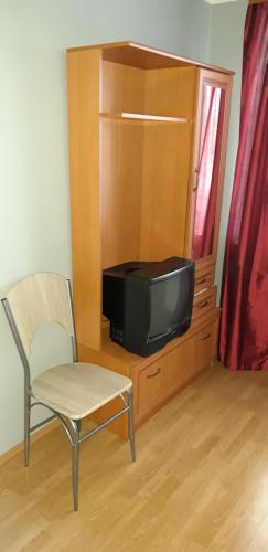 塔林Hansa Apartment的娱乐中心设有椅子和电视
