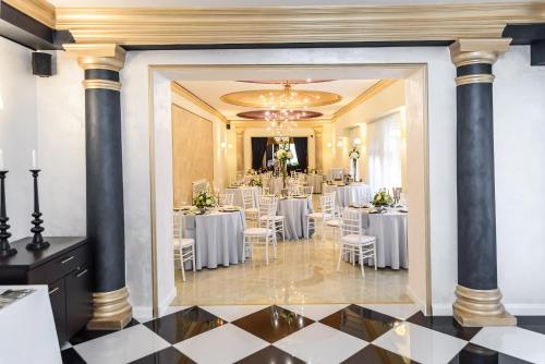 尼特拉Hotel Capital with private wellness的宴会厅配有白色的桌椅