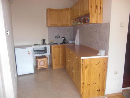 内塞伯尔Guest House Antoaneta的厨房配有木制橱柜和白色冰箱。