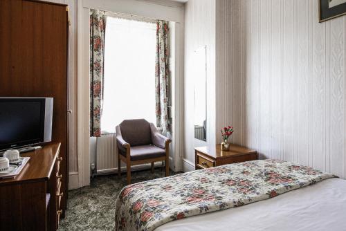 伦敦The Columbia的酒店的客房 - 带一张床、椅子和窗户