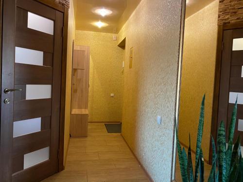 哈尔科夫New apartments with panoramic views on Avenue Nauky的走廊上有一扇门和一棵植物