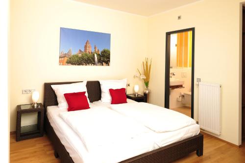 美因茨美因茨旅馆的卧室配有带红色枕头的大型白色床