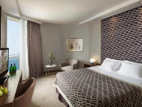 特拉维夫特拉维夫全景酒店的酒店客房设有一张大床和一张书桌。