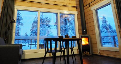 伊纳利LapinTintti Eco-Cabin in Inari的雪窗前的桌椅